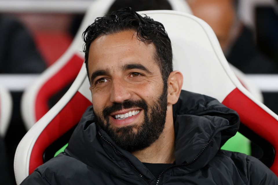 a man with a beard is smiling while sitting in a chair