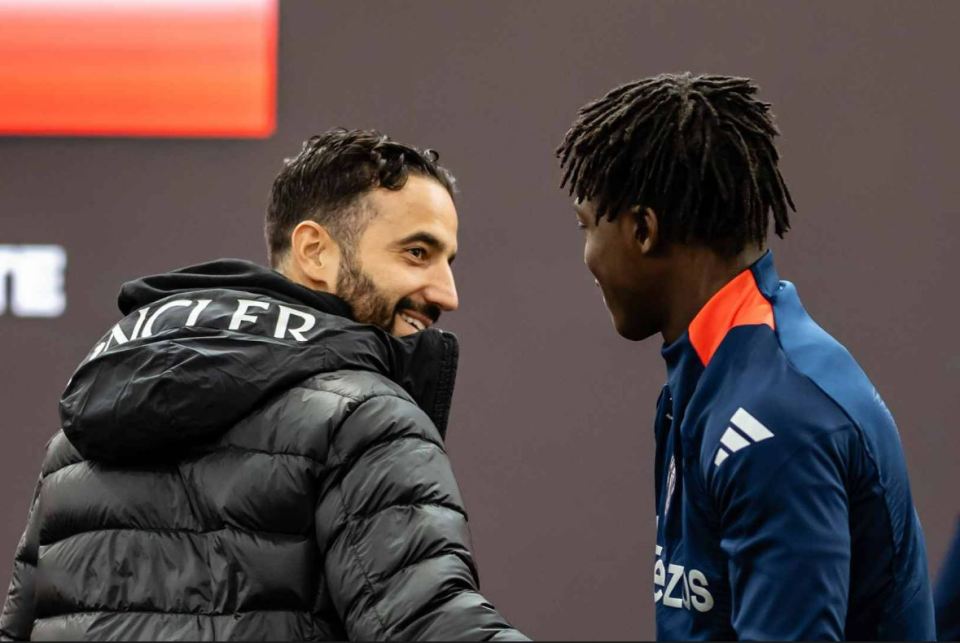 a man wearing a moncler jacket talks to another man