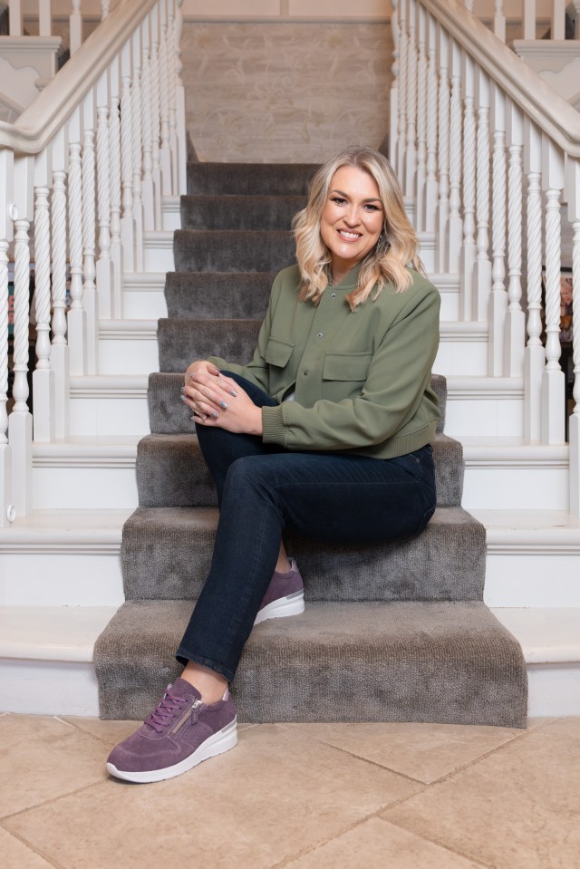 a woman sits on a set of stairs wearing purple shoes