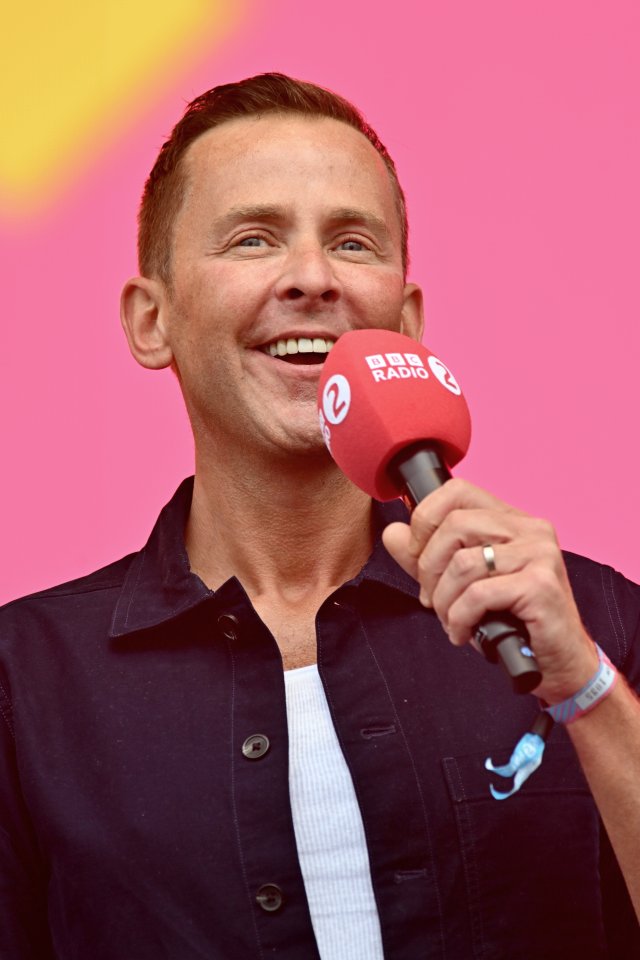 a man holding a microphone that says bbc radio 2