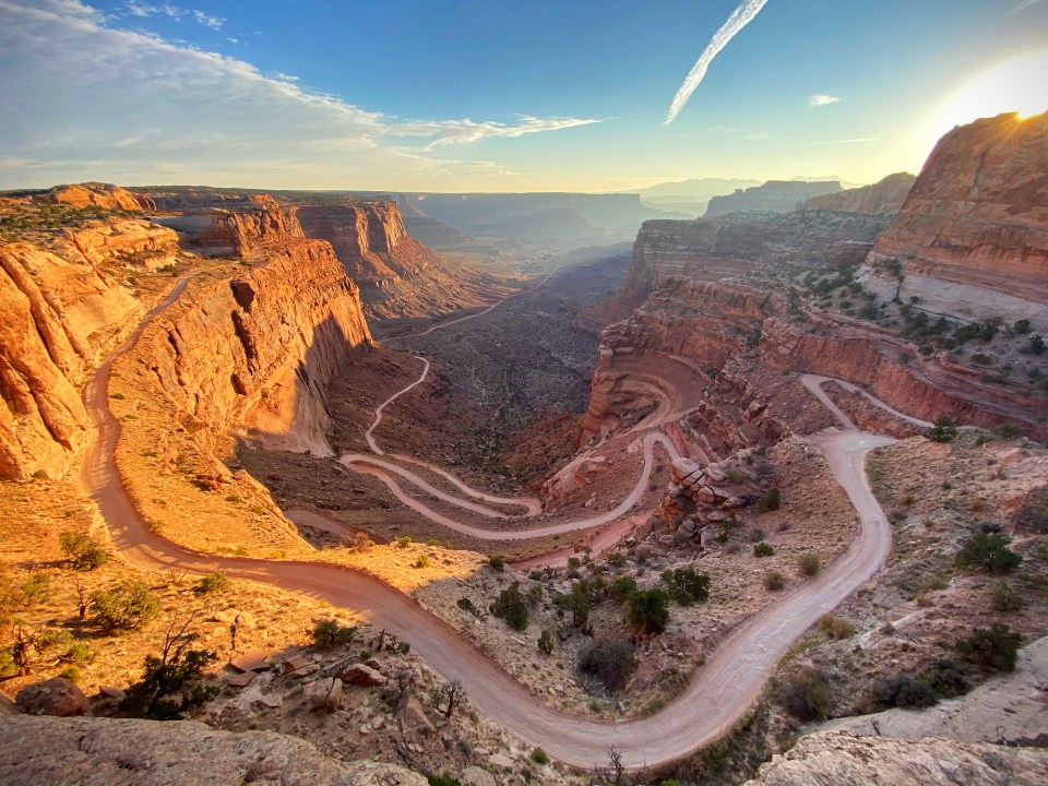 a dirt road winds through a canyon in the desert