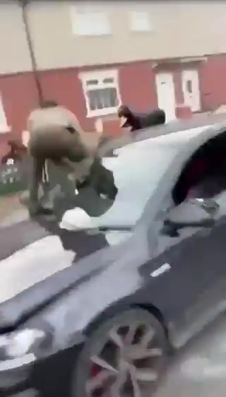 a group of people are standing on top of a car .