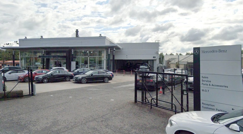 a mercedes benz dealership with cars parked in front of it