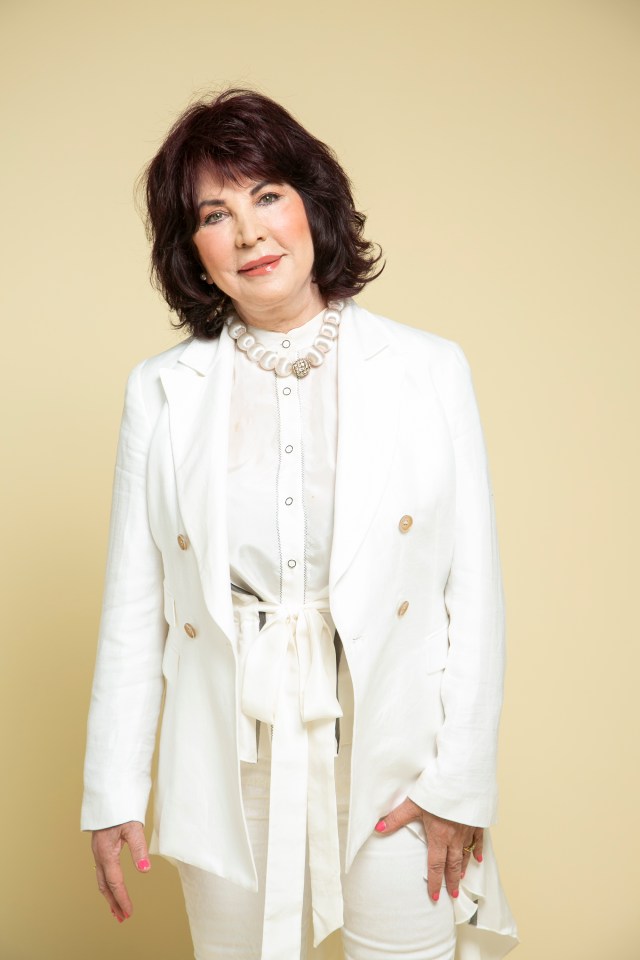 a woman wearing a white jacket and white pants