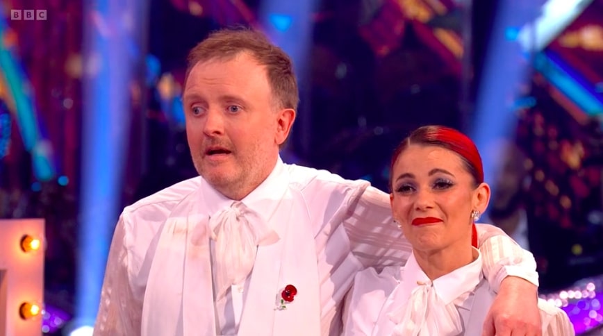 a man and a woman on a stage with bbc written on the bottom