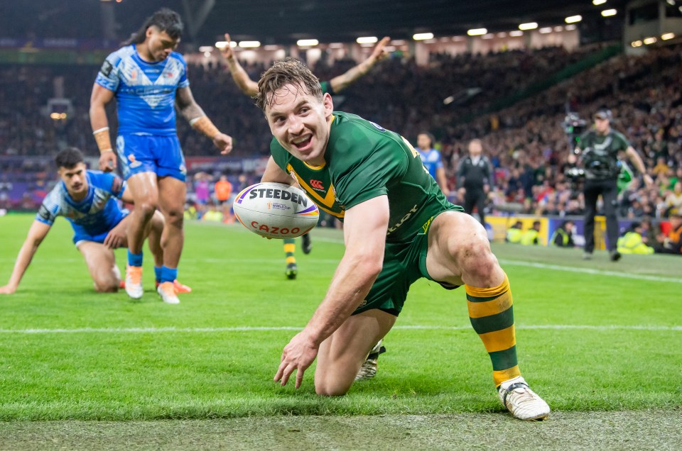a rugby player reaches for a ball that says steelden on it