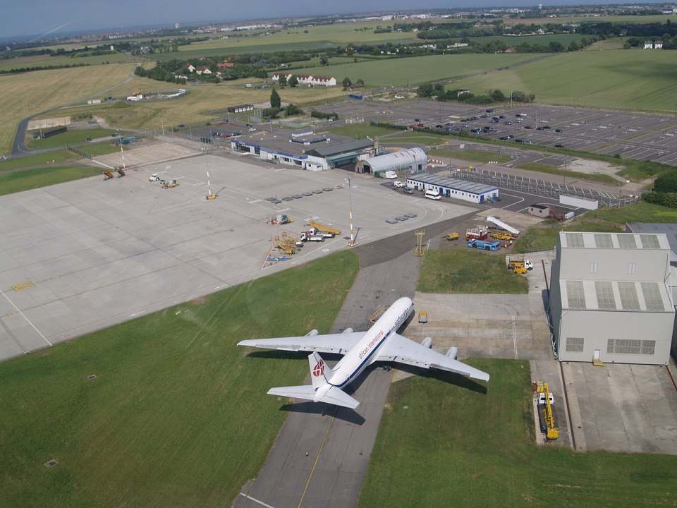 an aerial view of an airport with a plane on the runway