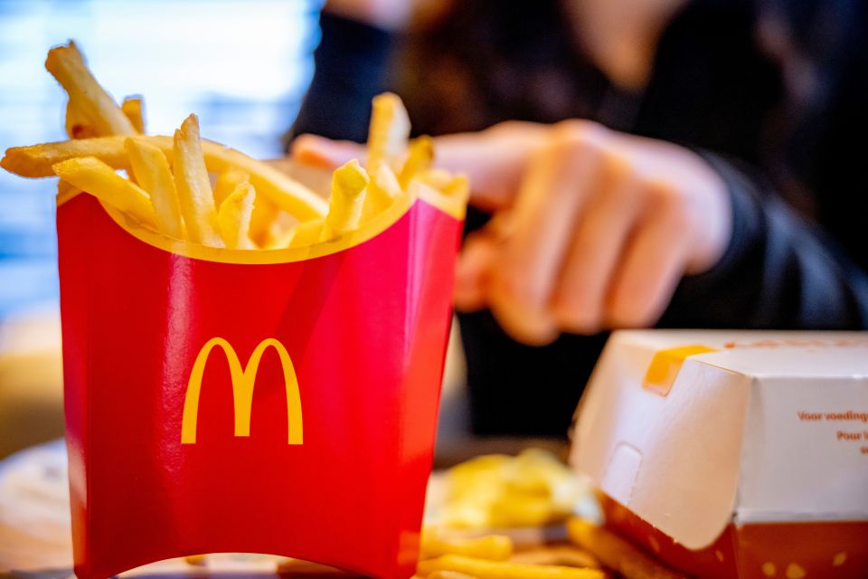 a person is taking french fries out of a mcdonald 's container