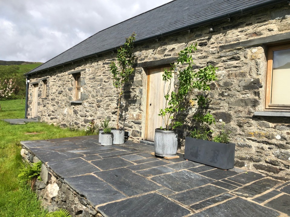 a stone building with potted plants in front of it