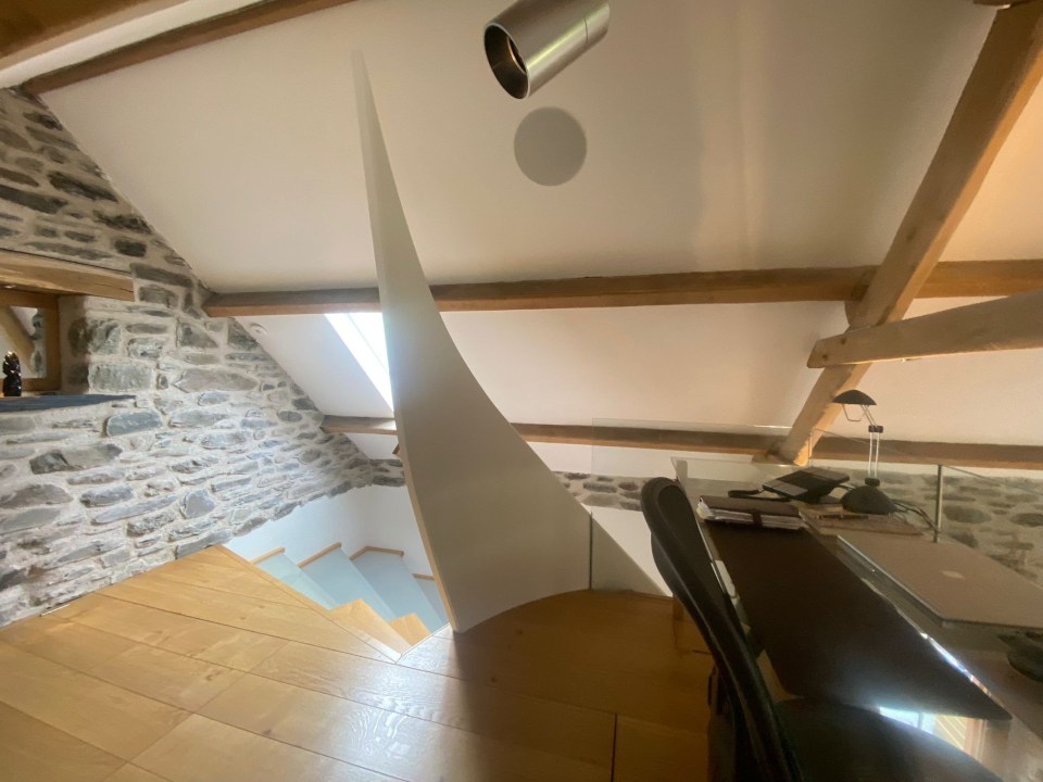 a staircase leading up to a desk with a laptop on it