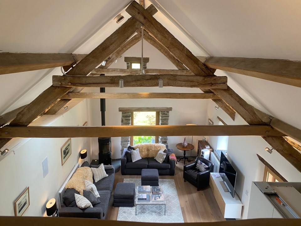 a living room with a vaulted ceiling and wooden beams