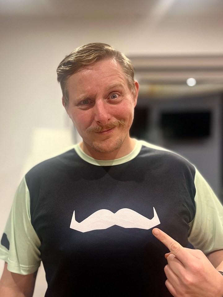 a man wearing a black shirt with a white mustache on it
