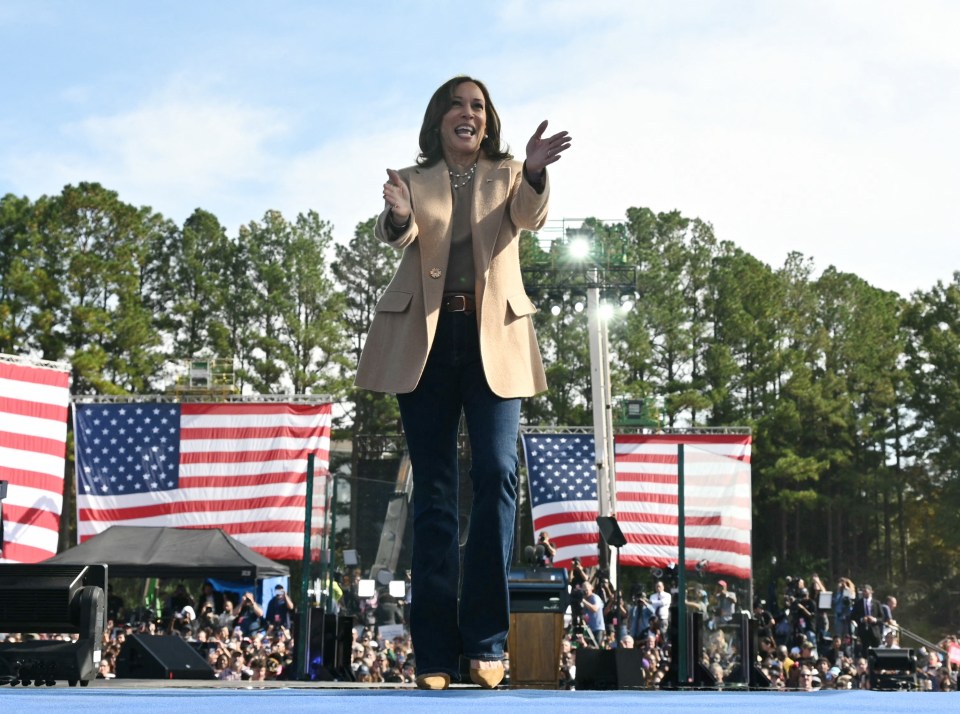 a woman giving a thumbs up in front of an american flag
