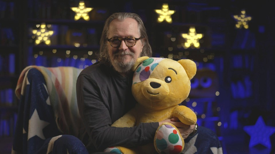 a man with glasses is holding a yellow teddy bear