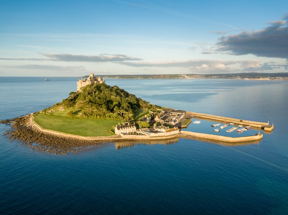 a small island in the middle of the ocean with a castle on top