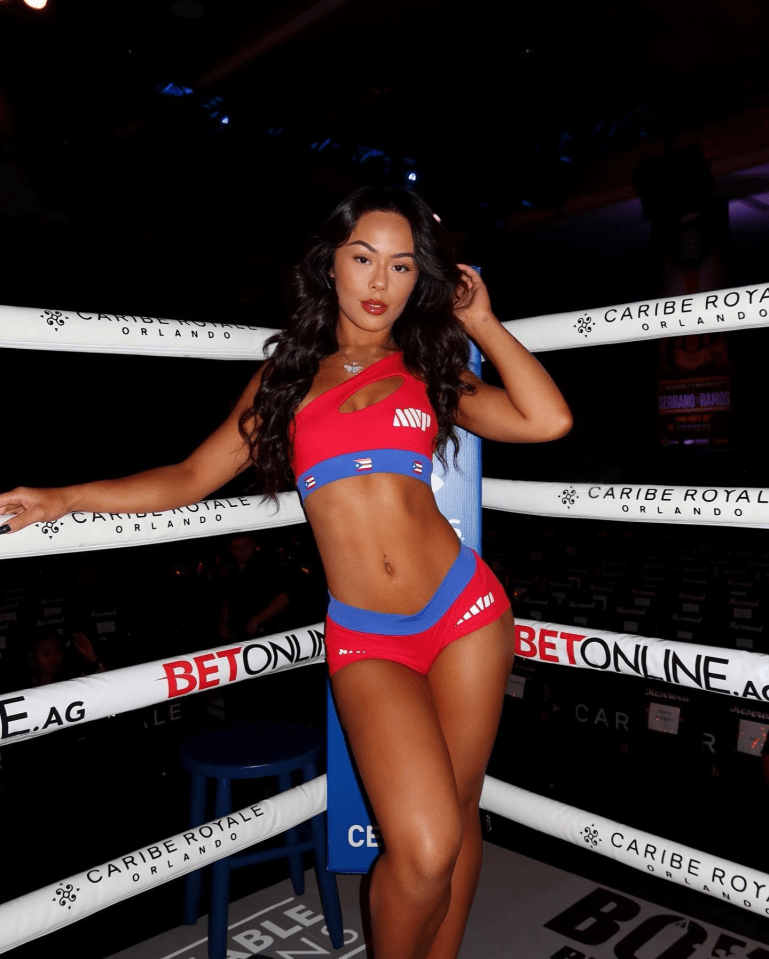 a woman in a bikini stands in a boxing ring sponsored by caribe royal orlando