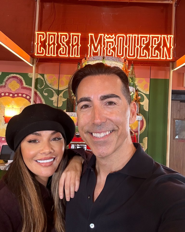 a man and woman pose in front of a sign that says casa mcqueen