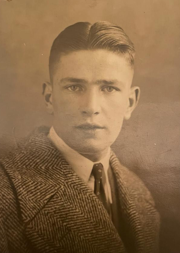a black and white photo of a young man in a suit and tie