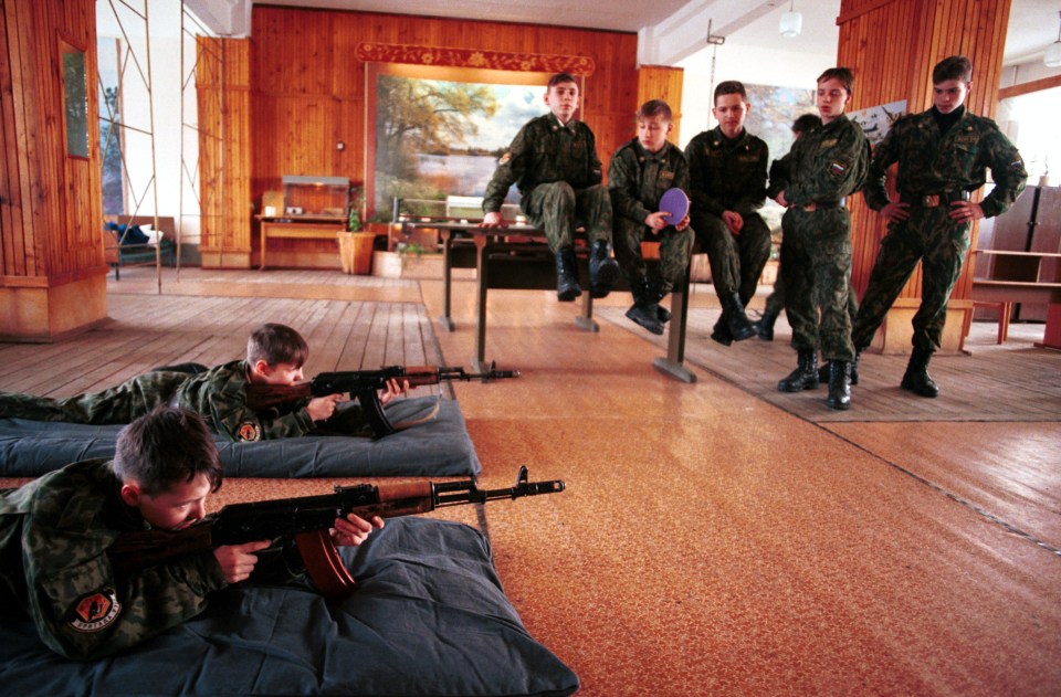 Orphaned children in Russia receive military training, learning to fire rifles.