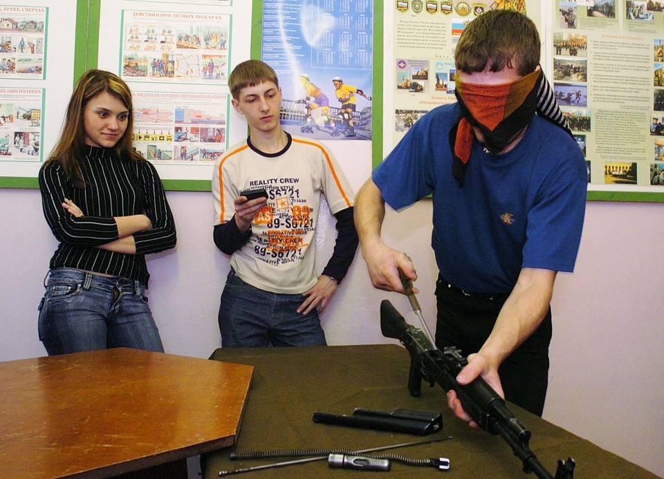 Blindfolded Russian student disassembling an AK-47 rifle.