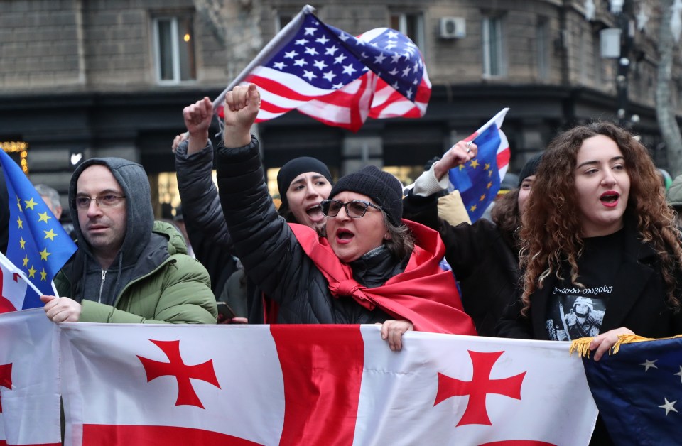 Georgian opposition protestors holding Georgian and US flags.