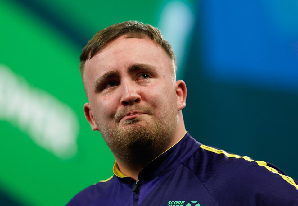 Luke Littler celebrates winning his darts match.