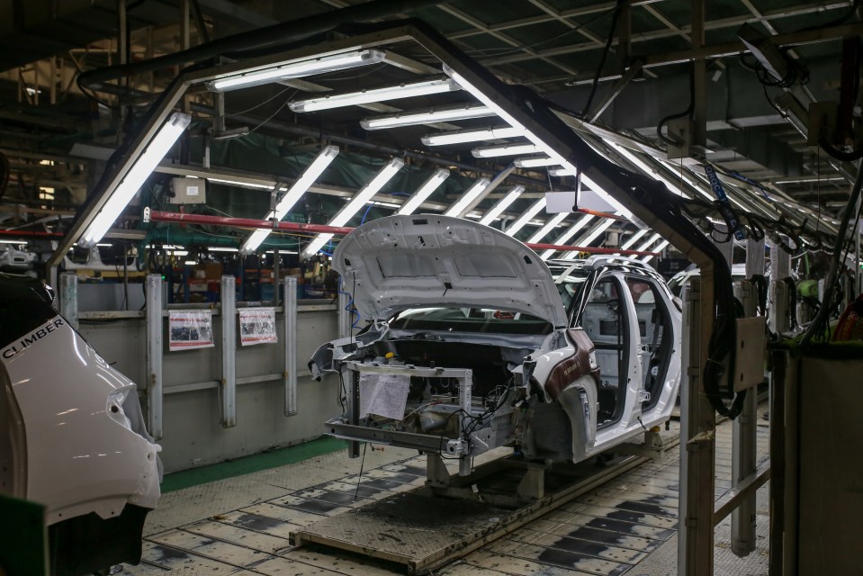 Car bodies on an assembly line in a factory.