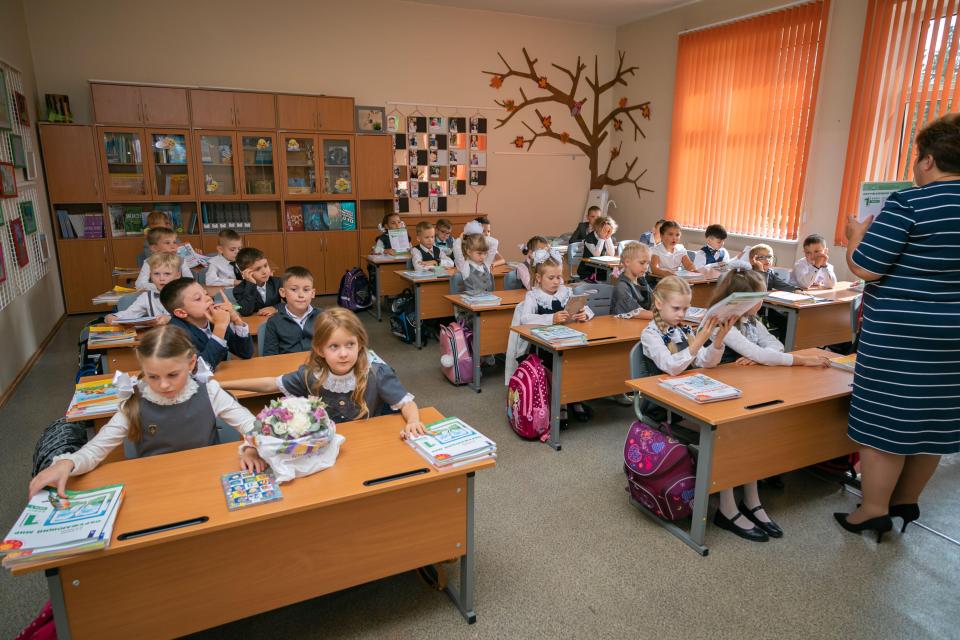 First graders in a Moscow classroom listen to their teacher.