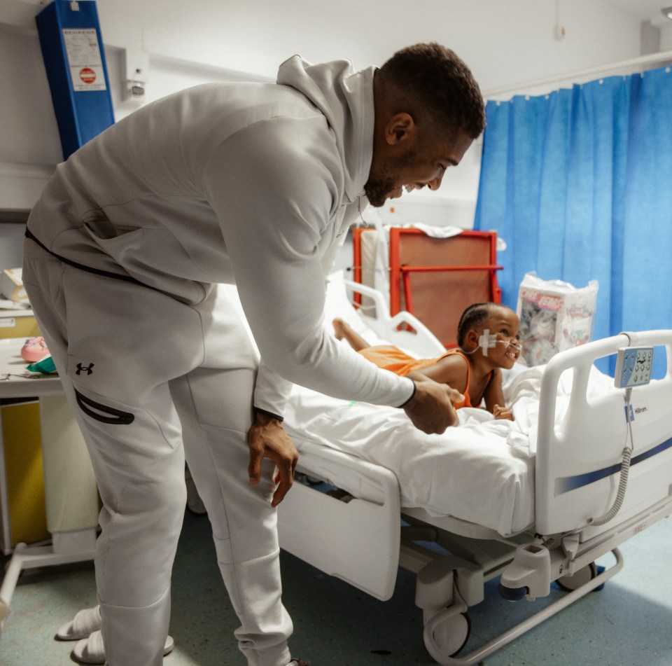 Anthony Joshua visits children in a hospital ward.