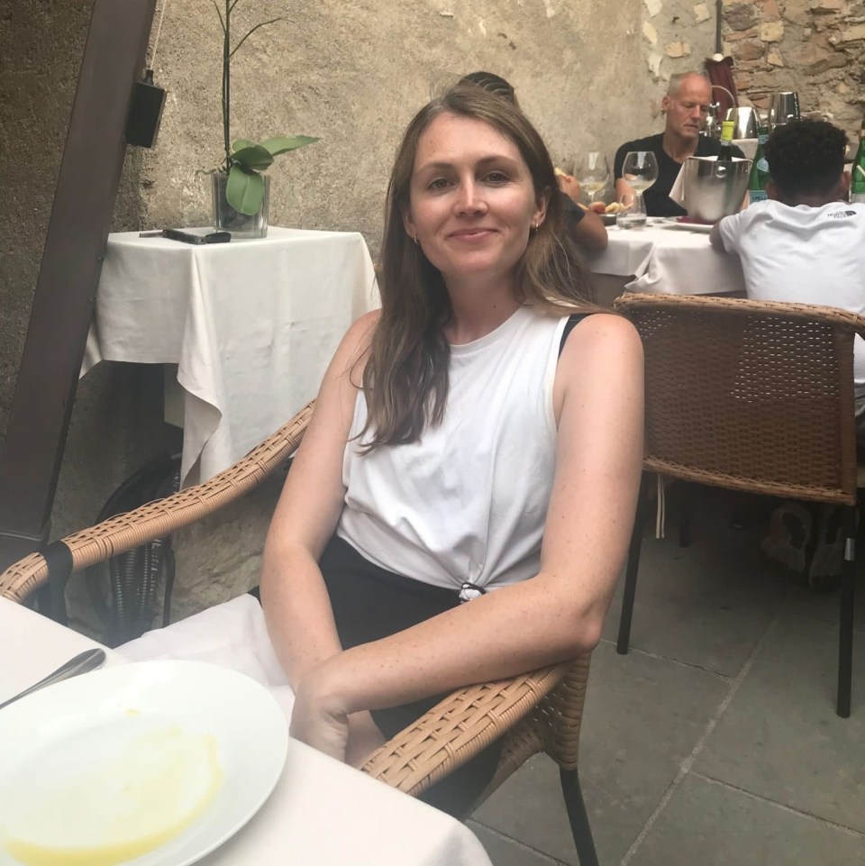 Woman sitting at an outdoor restaurant table.