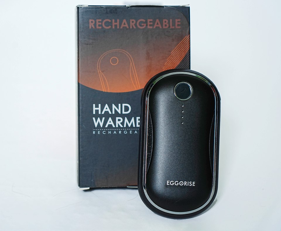 A woman holding a red hand warmer.