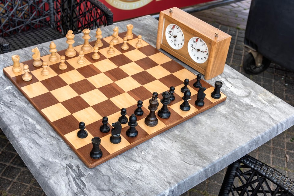 chessboard with chess pieces and a chess clock
