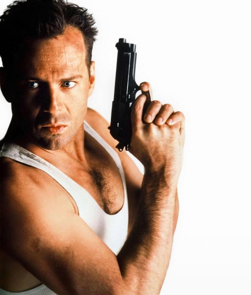 Bruce Willis holding a gun in Die Hard.