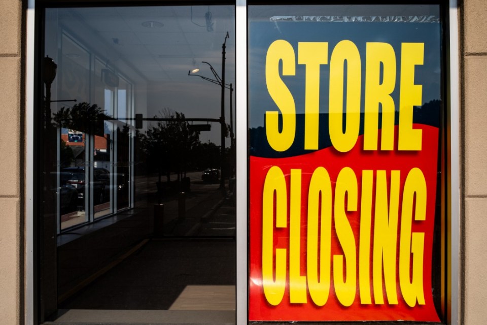 Store closing sign in a storefront window.