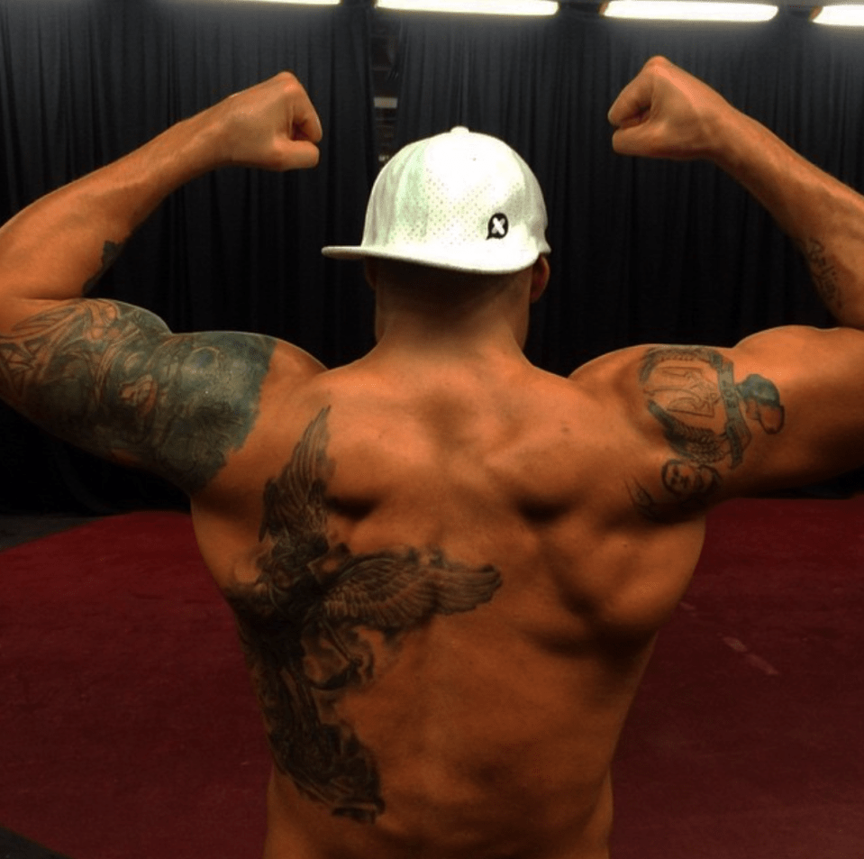 Muscular man's back with large angel wing tattoo.