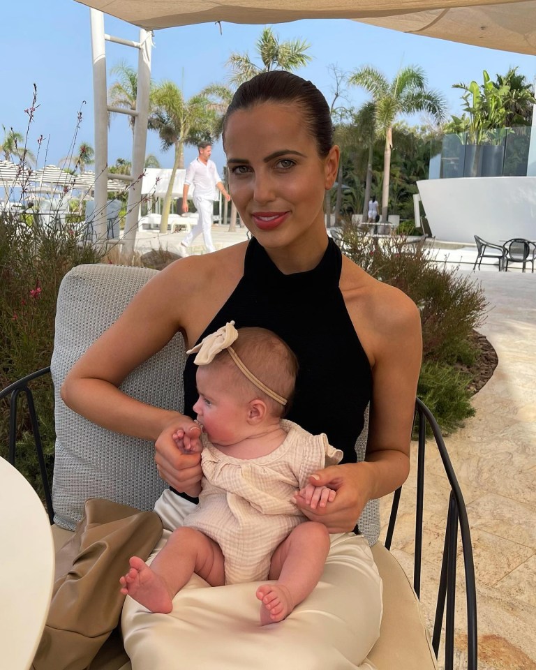 Woman holding baby outdoors.