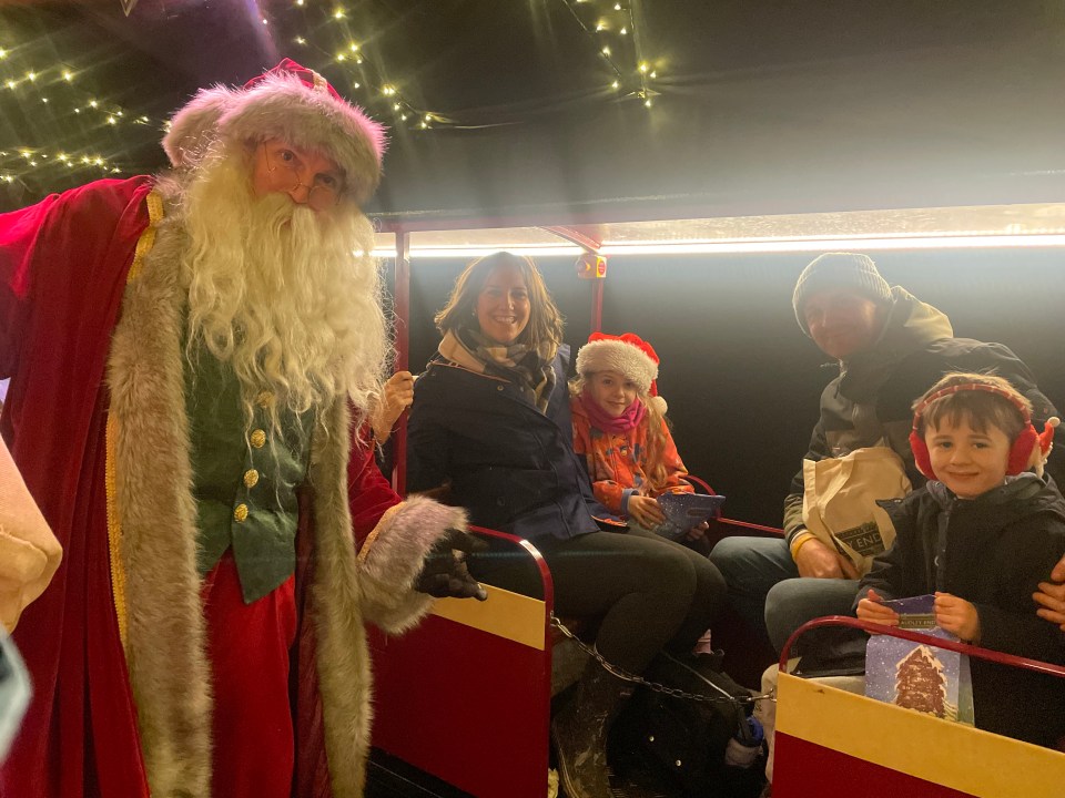 Family riding on a Christmas train with Santa.