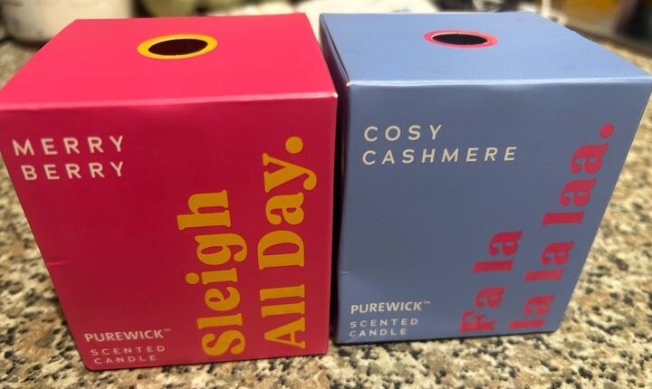 Two Purewick scented candles: Merry Berry and Cosy Cashmere.