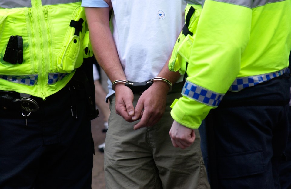 Police officers handcuffing a man.