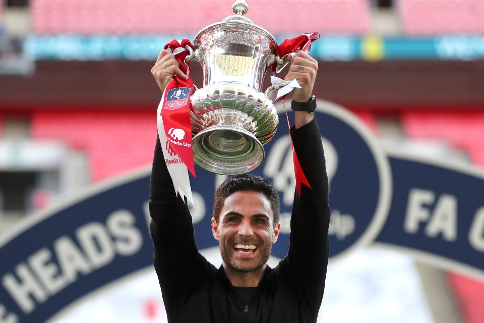 Mikel Arteta holding the FA Cup trophy.