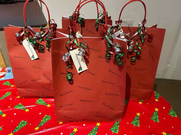 Several red gift bags decorated with "Merry Christmas" and ribbons.