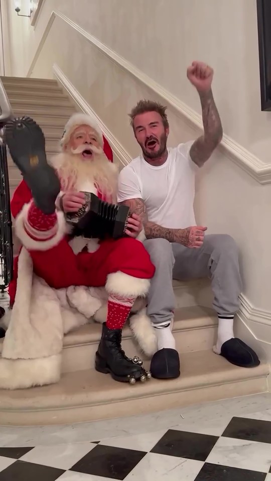 Santa Claus plays an accordion while David Beckham sings along.