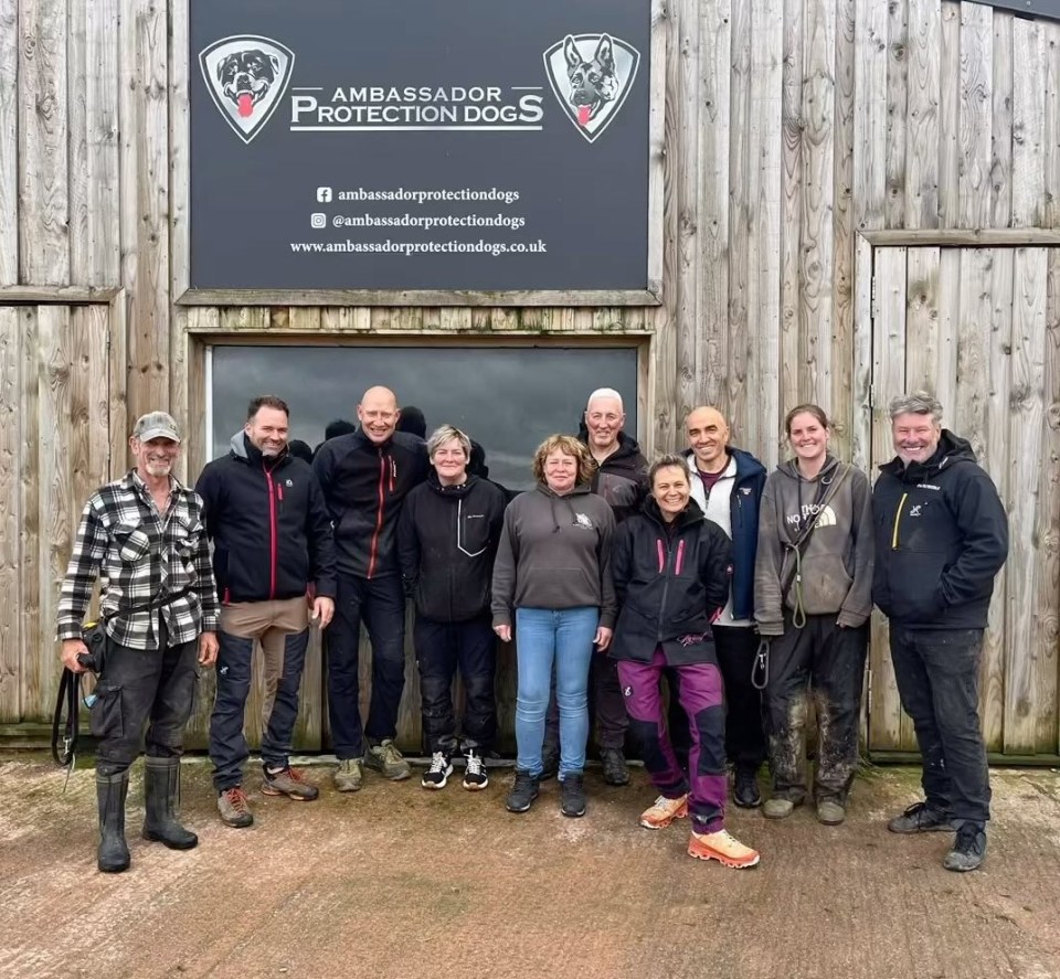 Group photo of Ambassador Protection Dogs staff in front of their building.