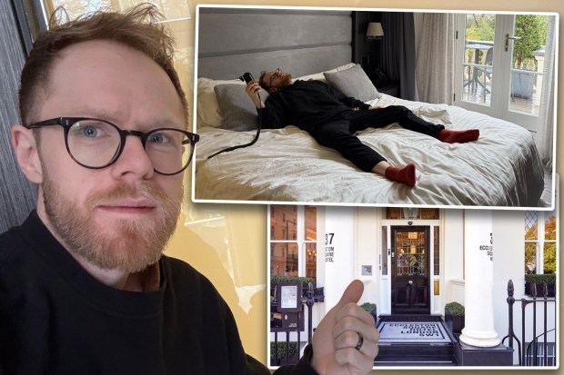 Man in glasses gives thumbs up to Eccleston Square Hotel in London, where he is relaxing in bed.