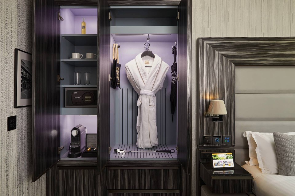 Hotel room closet with bathrobe, coffee maker, and safe.