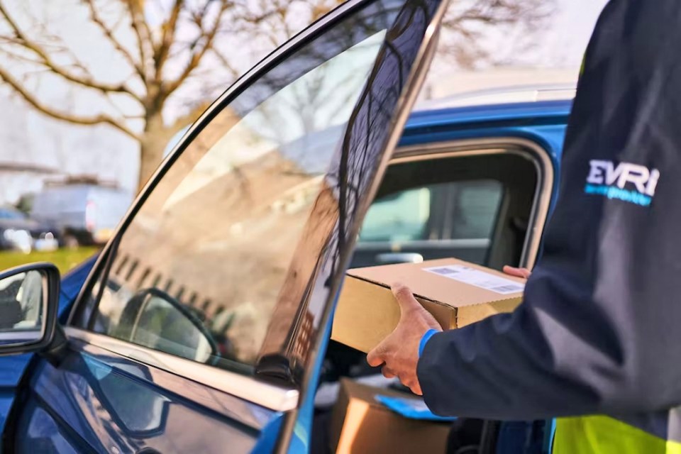 Delivery driver placing package in car.