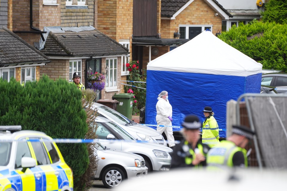 Crime scene investigators at a house where three women were murdered.