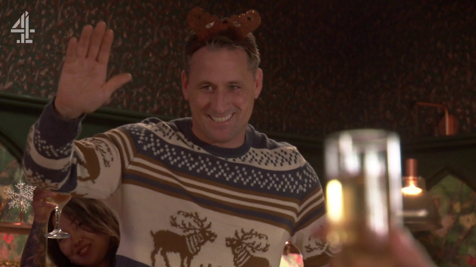 Hollyoaks winter trailer: A man in a reindeer sweater waves.