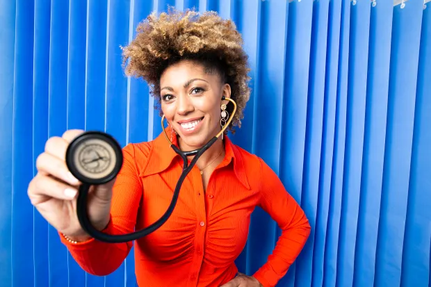 A smiling woman doctor holding a stethoscope.