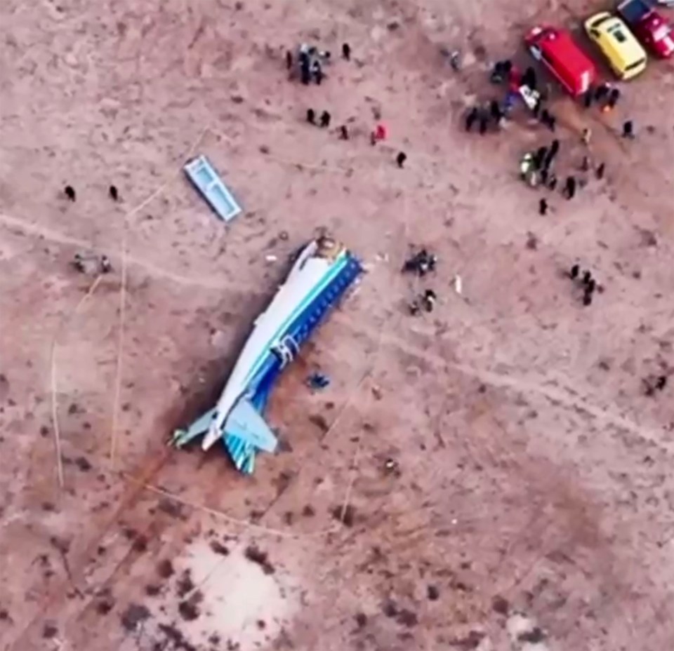 Airplane crash site with emergency personnel.